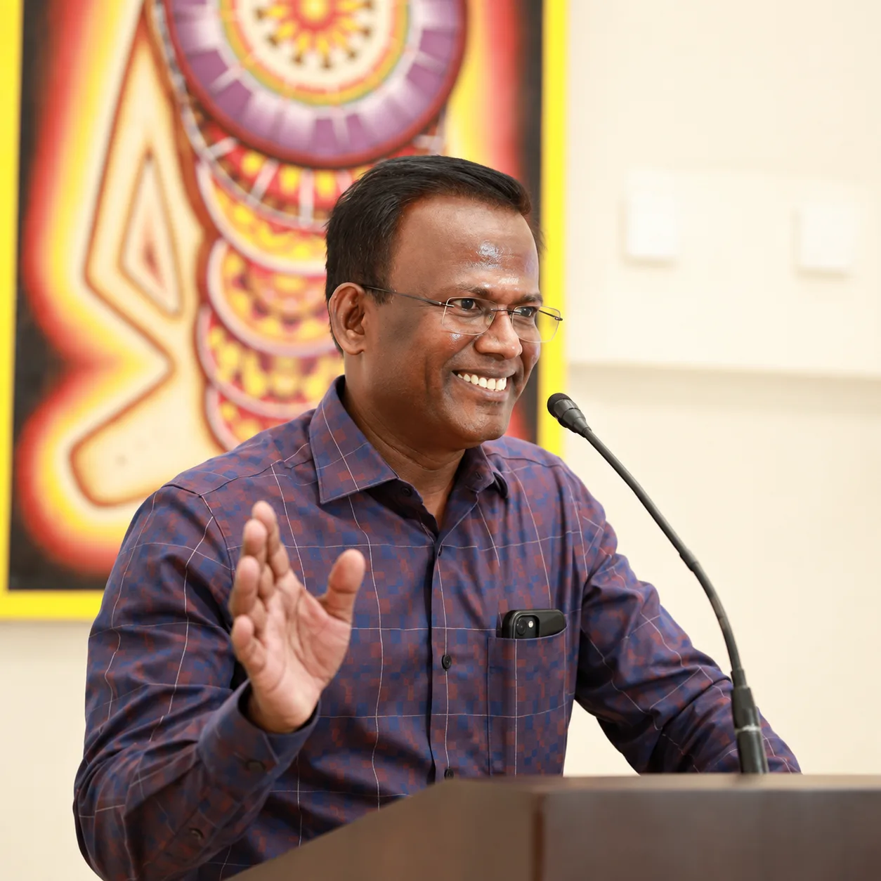 Adv. K Rajesh Kannan speaking at a podium